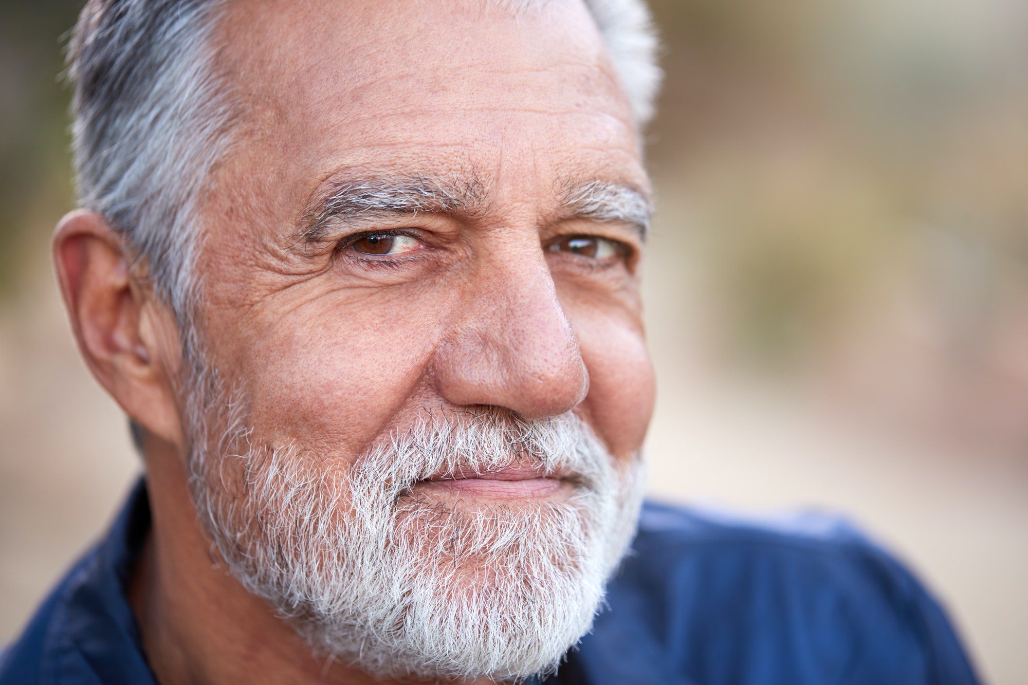 outdoor portrait of serious hispanic senior man with mental health concerns