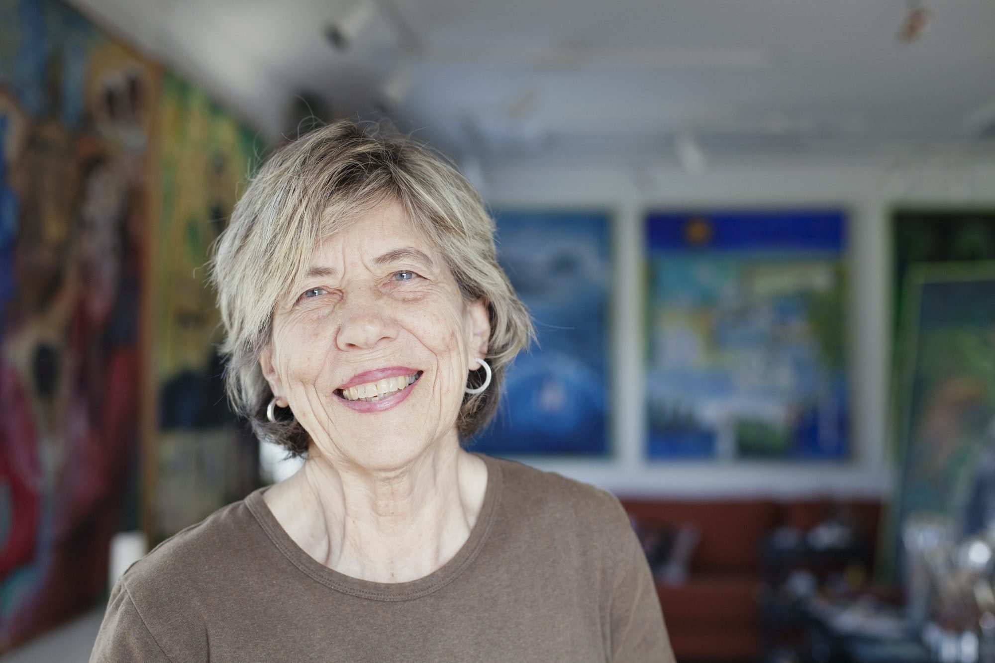 Portrait of smiling senior female artist in art studio