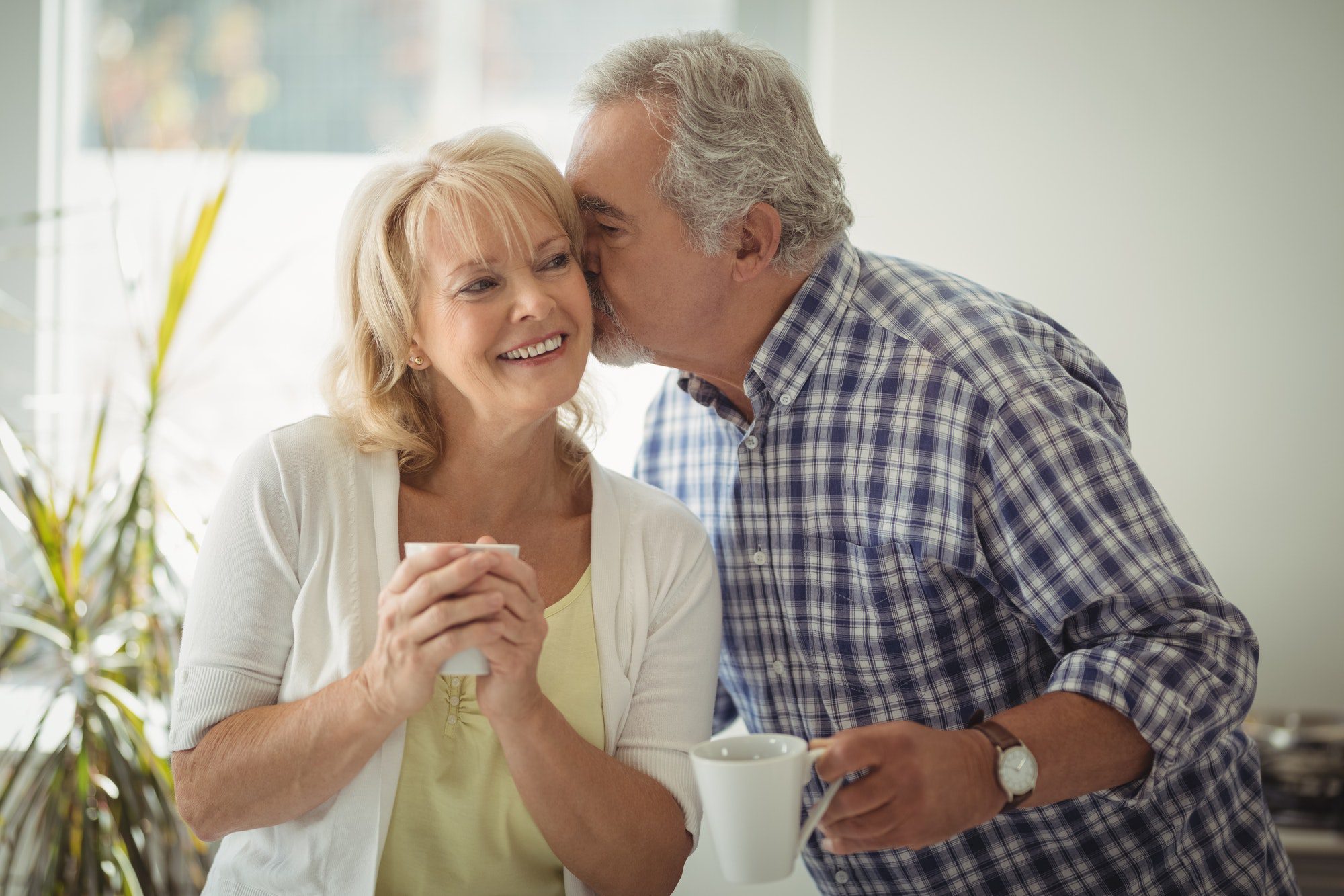 Senior man kissing senior woman celebrating their household discount for a Medigap Plan with Aetna.