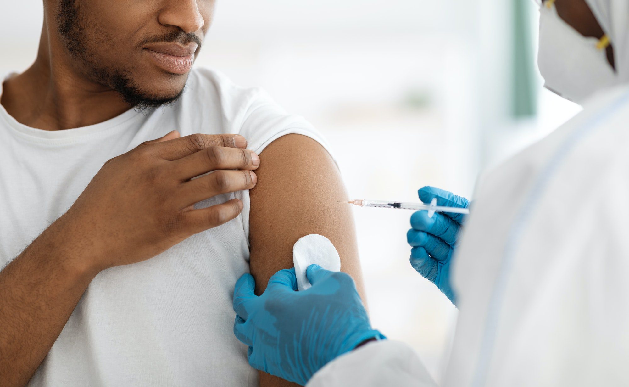 cropped of black man receiving vaccine shot