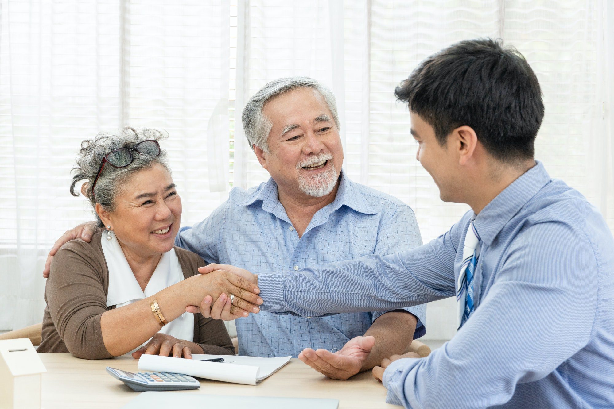 Happy senior couple meets with agent to learn how to avoid medicare penalties.