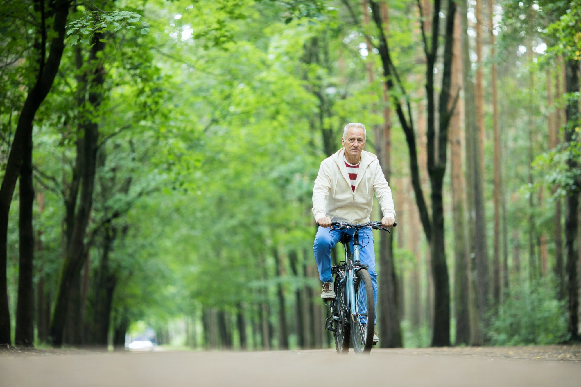 Senior man riding his bike as he thinks about the donut hole is medicare part d coverage has.