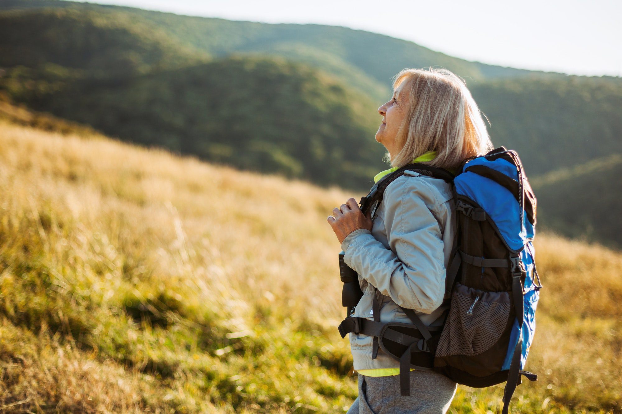 Senior woman hiking as she contemplates attained age and issued age.