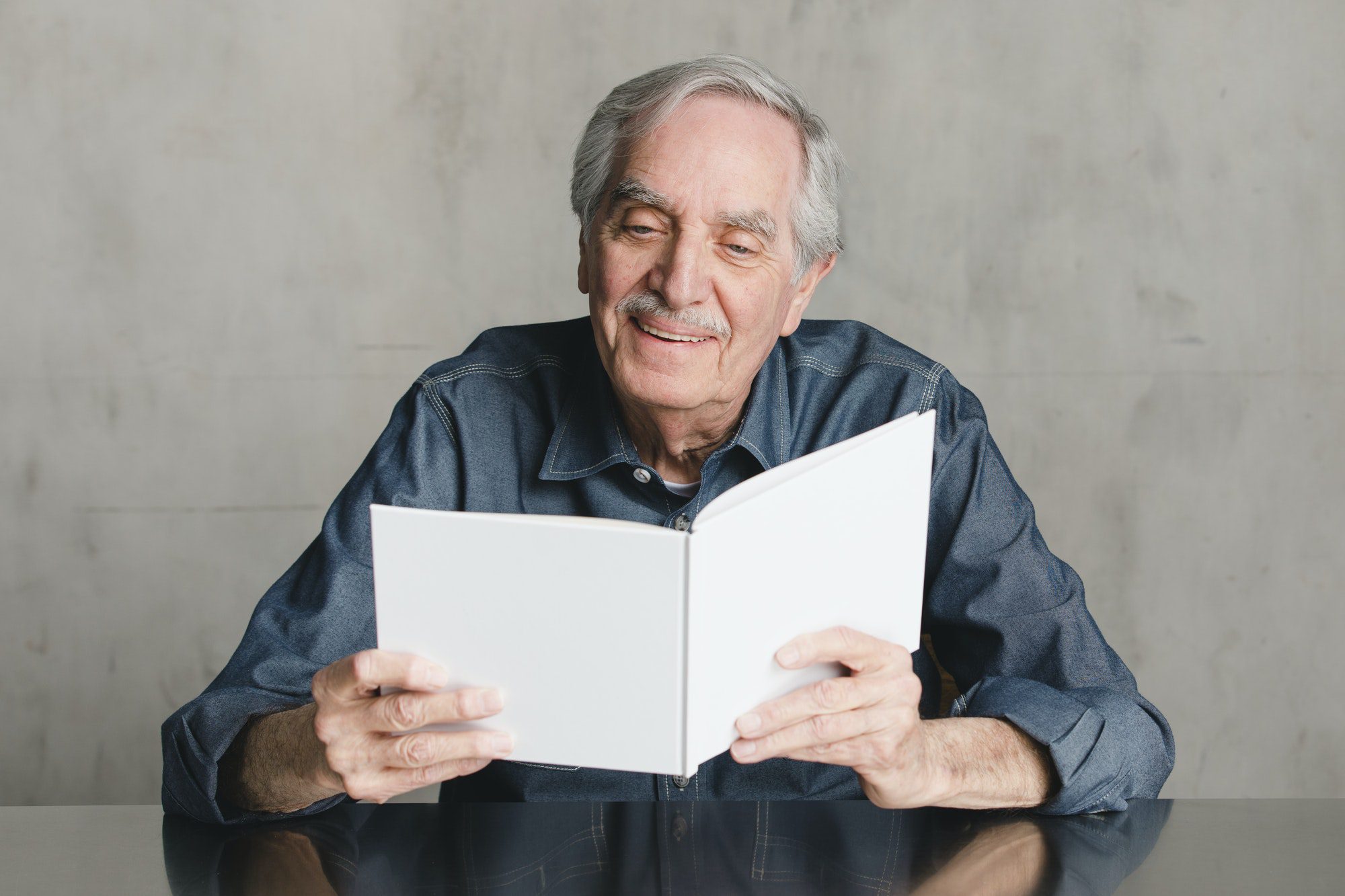 Happy senior man reading a book of everything you should know about Medigap plan F.