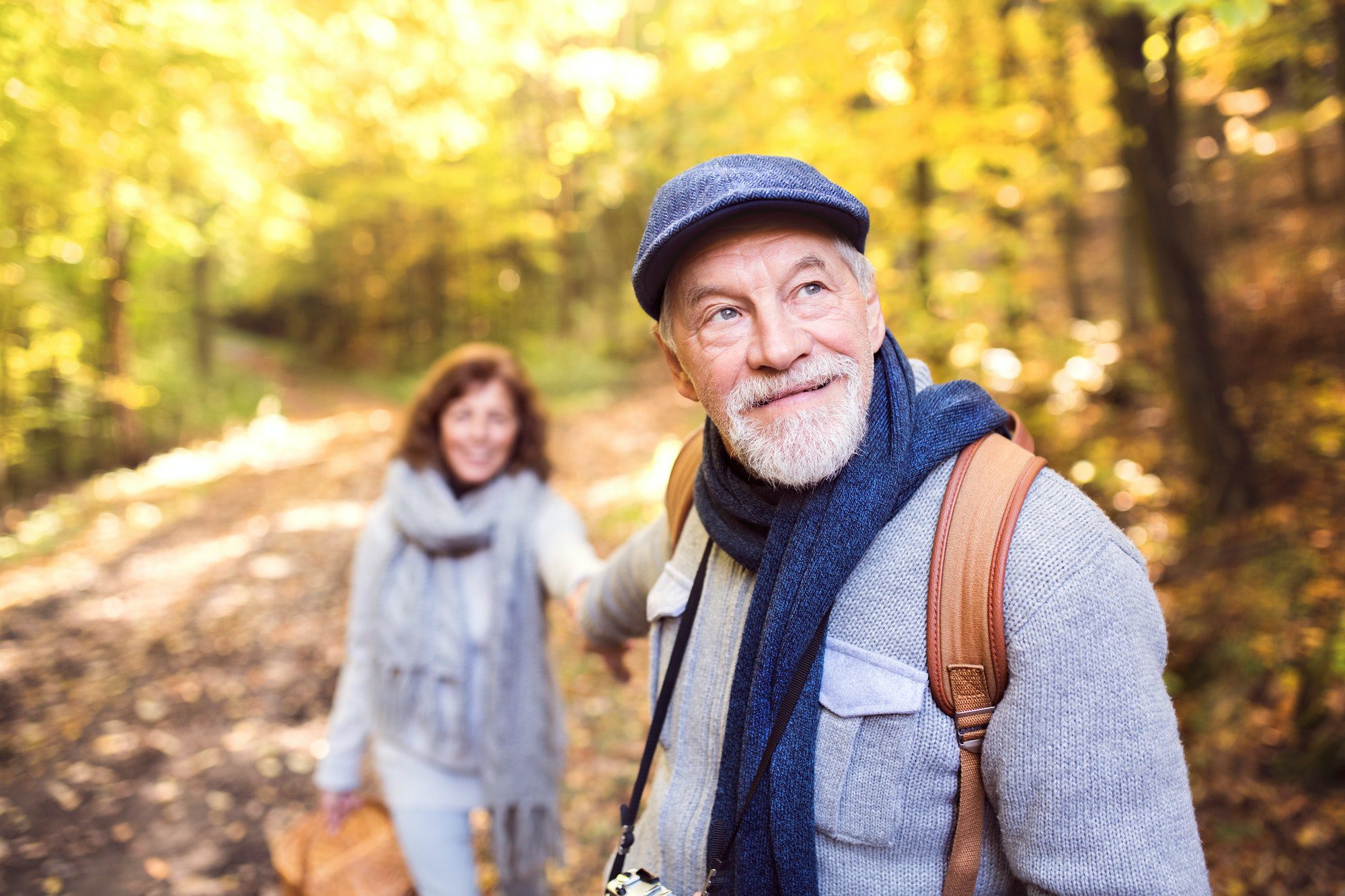 Senior couple on a walk in autumn forest as they discuss medigap Plan G.