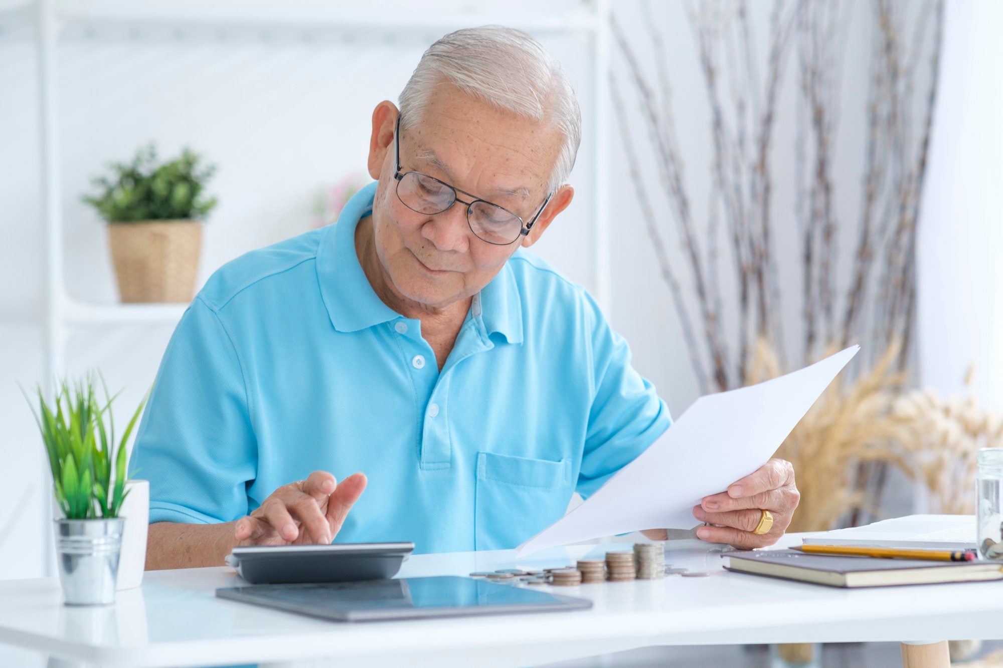 Senior man calculating finances learning the Drawbacks of Plan F